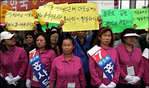 13일 오후 경기도 광주 국회의원 재선거 한나라당 정진섭 후보 지원에 나선  박근혜 대표가 광주의 한 재래시장을 돌자 무소속 홍사덕 후보의 지지자들이 박 대표를 향한 호소문을 들어보이며 침묵 시위를 벌이고 있다. 